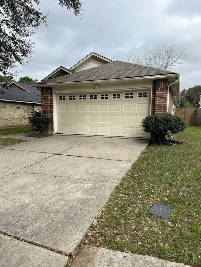 garage with fence and driveway