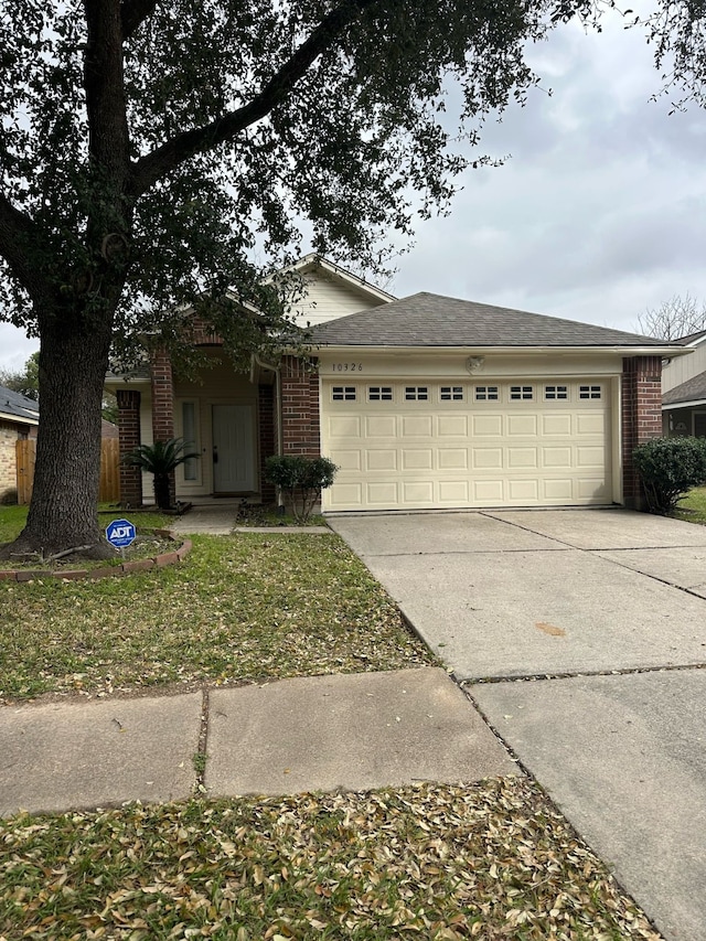 single story home featuring brick siding, an attached garage, and driveway