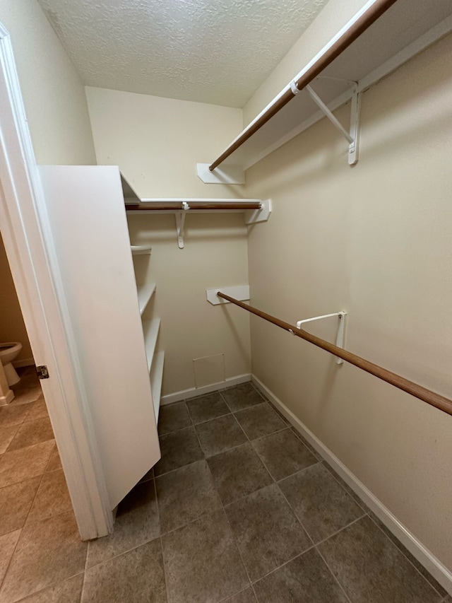 walk in closet with tile patterned floors