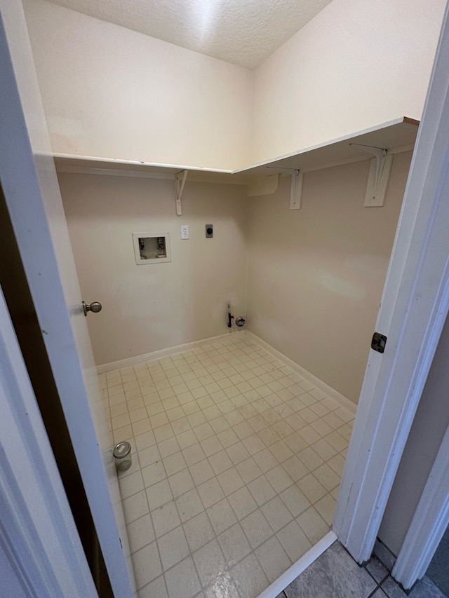 clothes washing area with laundry area, hookup for a washing machine, a textured ceiling, tile patterned floors, and electric dryer hookup