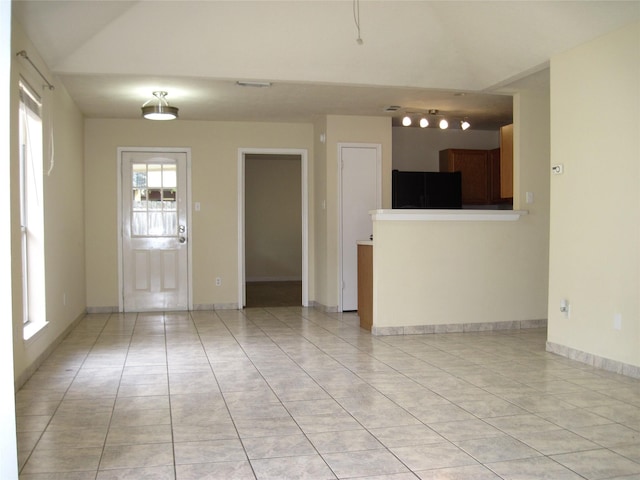 unfurnished living room featuring baseboards and light tile patterned floors