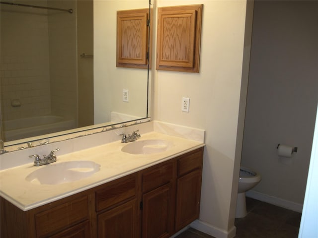 bathroom featuring a sink, tile patterned flooring, toilet, and double vanity