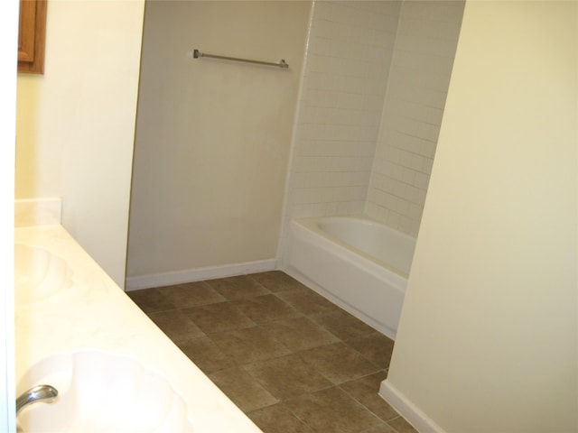 bathroom featuring double vanity, a sink, and baseboards