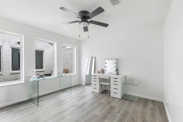 office area featuring baseboards, a ceiling fan, visible vents, and light wood-style floors