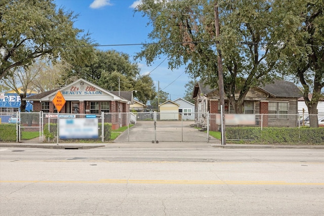 view of road with traffic signs, a gate, and curbs