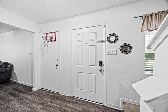 foyer featuring dark wood-style floors, a textured ceiling, and baseboards