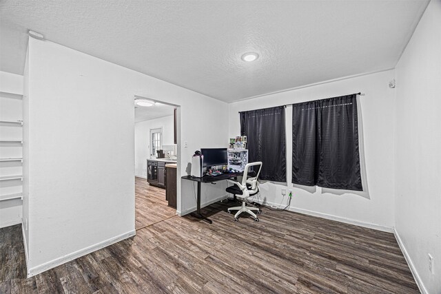 office space with a textured ceiling, baseboards, and wood finished floors