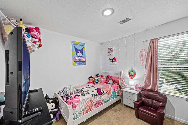 bedroom featuring baseboards, multiple windows, visible vents, and a textured ceiling