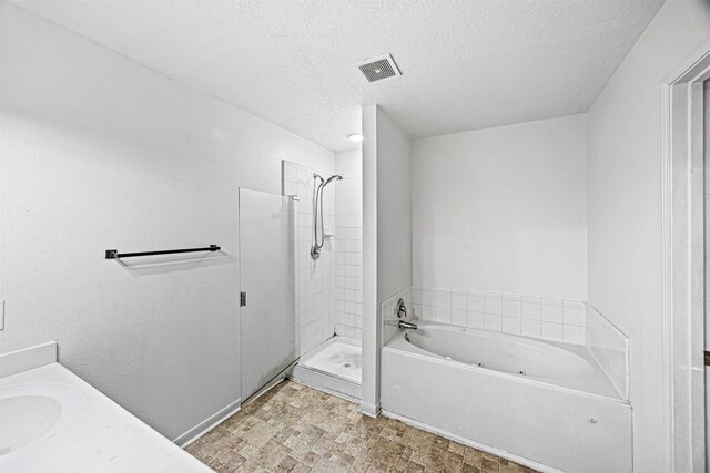 bathroom with a textured ceiling, vanity, visible vents, a shower stall, and a tub with jets