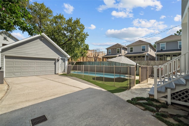 view of yard with a garage, visible vents, fence, and a fenced in pool