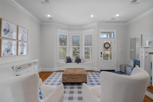 sitting room featuring light wood-style floors, baseboards, crown molding, and recessed lighting