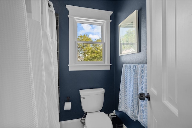 bathroom with toilet and a shower with shower curtain