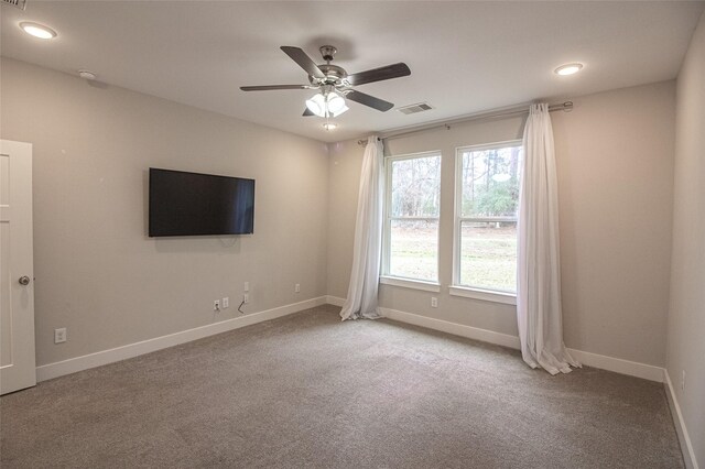 unfurnished room with a ceiling fan, carpet flooring, visible vents, and baseboards