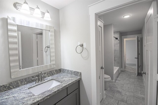 bathroom with a shower, vanity, and toilet