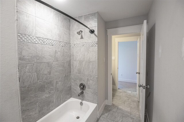 bathroom featuring shower / bath combination and baseboards