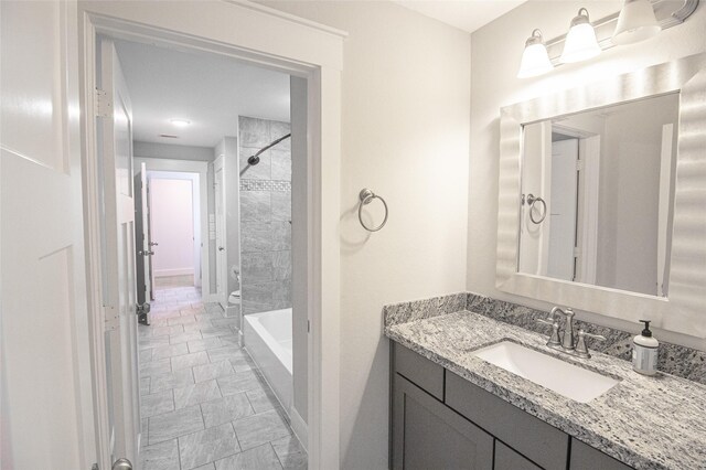 bathroom with  shower combination, baseboards, and vanity