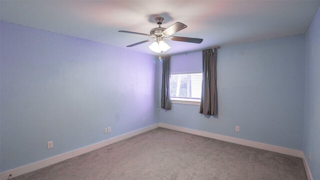 spare room featuring carpet floors, ceiling fan, and baseboards