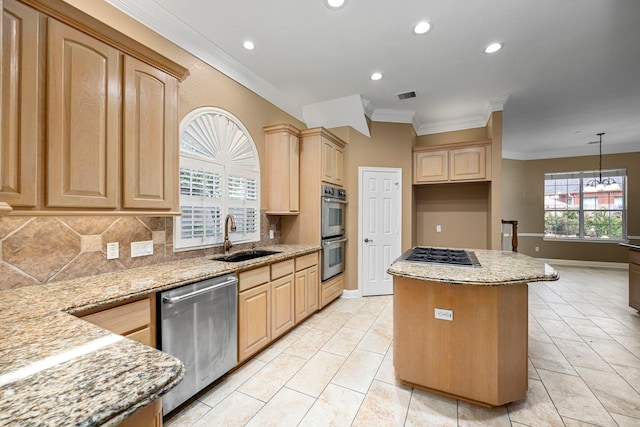 kitchen featuring stainless steel appliances, light brown cabinetry, a sink, and decorative light fixtures