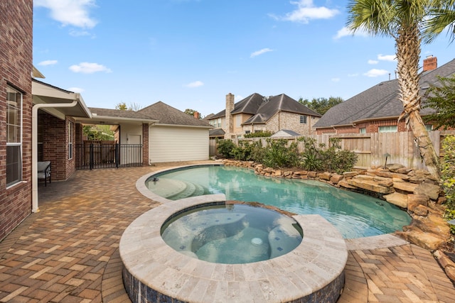 view of pool featuring a patio, a fenced backyard, and a pool with connected hot tub