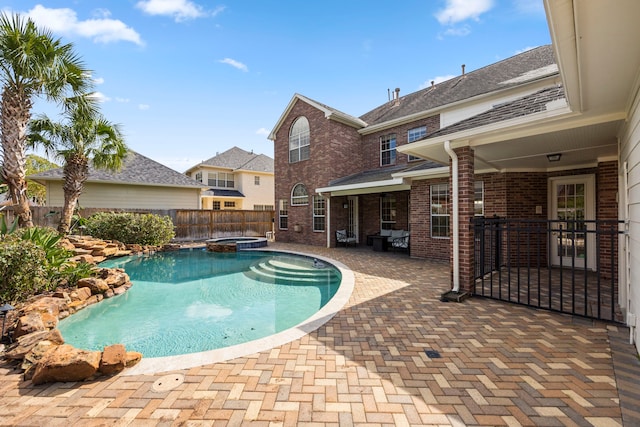 view of swimming pool featuring a patio, a fenced backyard, and a pool with connected hot tub