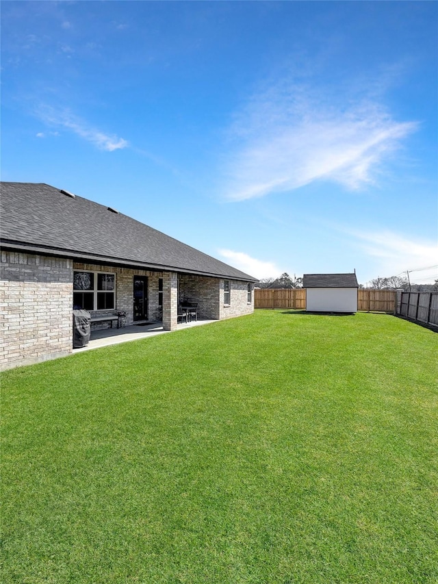 view of yard featuring an outbuilding, a patio area, a fenced backyard, and a shed