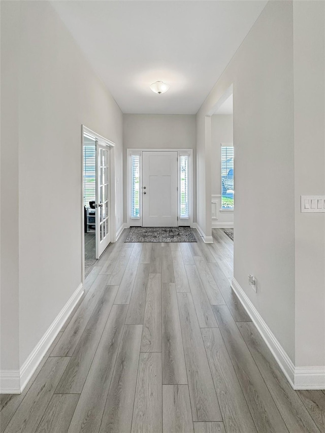 entryway with light wood finished floors and baseboards