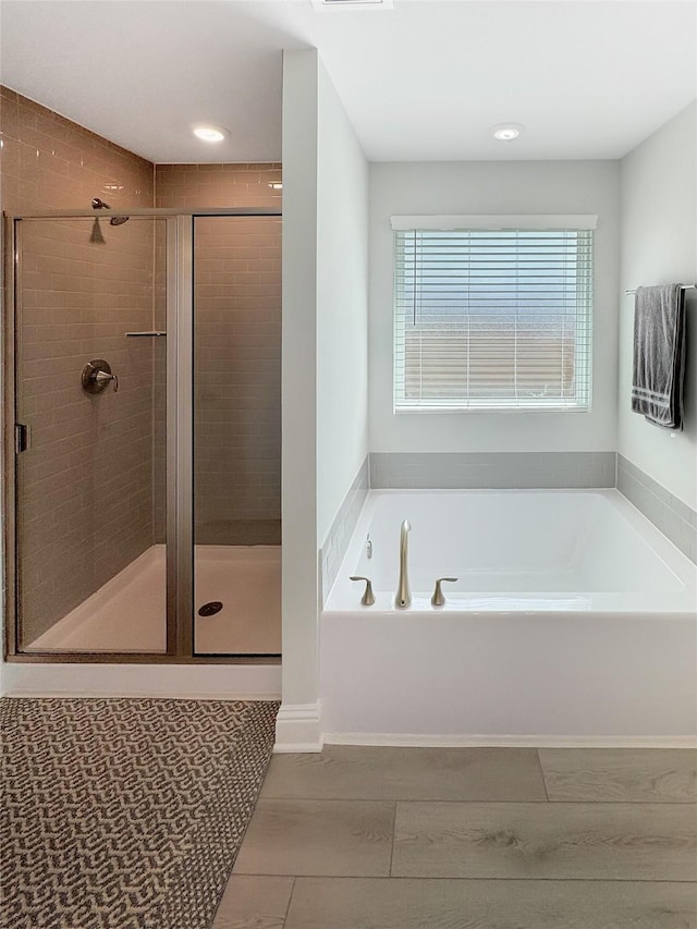 bathroom with a shower stall and a bath