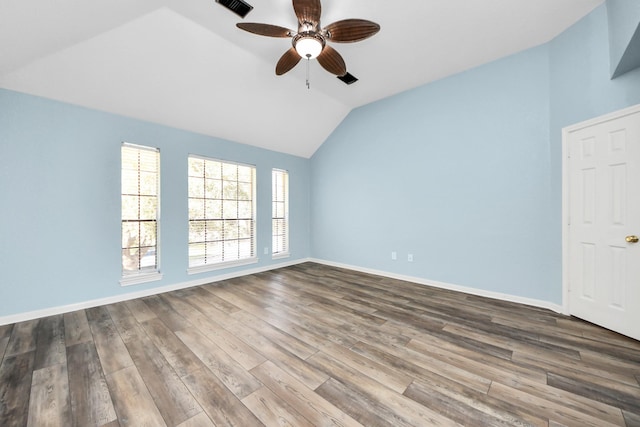 unfurnished room with wood finished floors, visible vents, a ceiling fan, vaulted ceiling, and baseboards