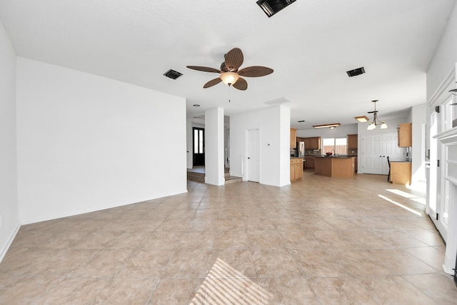 unfurnished living room with light tile patterned floors, baseboards, visible vents, and a ceiling fan