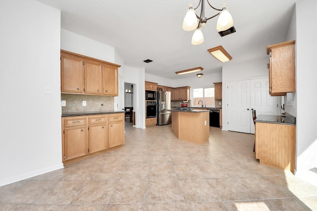 kitchen featuring dark countertops, black appliances, decorative backsplash, and a center island