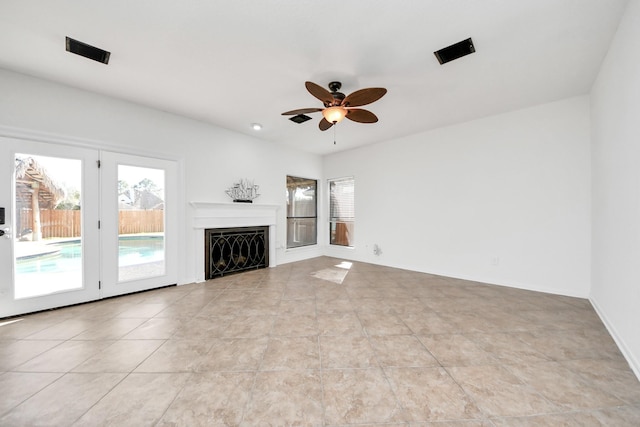 unfurnished living room with ceiling fan, a fireplace, and light tile patterned flooring