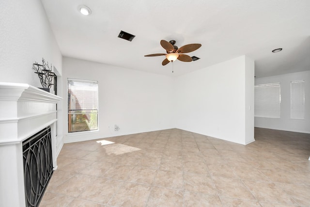 unfurnished living room with light tile patterned floors, ceiling fan, a fireplace, and visible vents