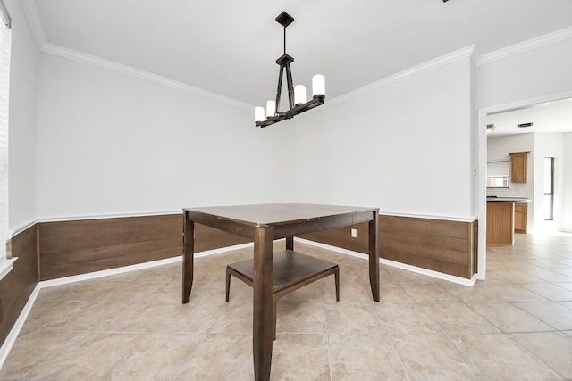 dining room featuring a wainscoted wall, crown molding, light tile patterned floors, wood walls, and a chandelier