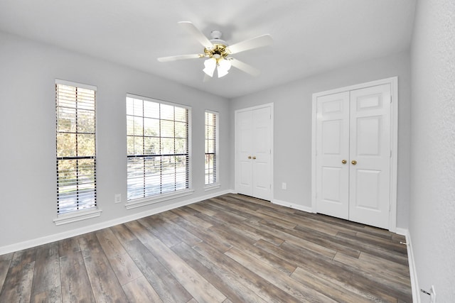 interior space featuring ceiling fan, baseboards, and wood finished floors