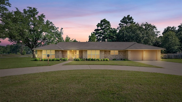 single story home featuring a garage, a front lawn, concrete driveway, and brick siding