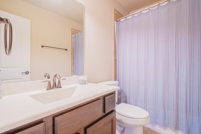 bathroom with curtained shower, vanity, and toilet