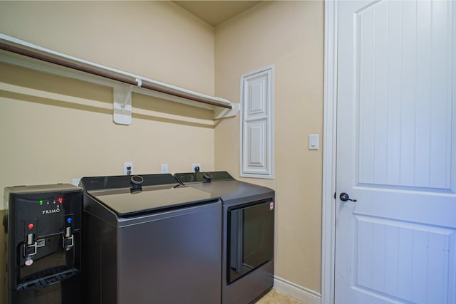 washroom with laundry area, baseboards, and washer and dryer