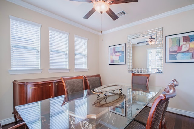 dining space featuring dark wood finished floors, visible vents, ornamental molding, a ceiling fan, and baseboards