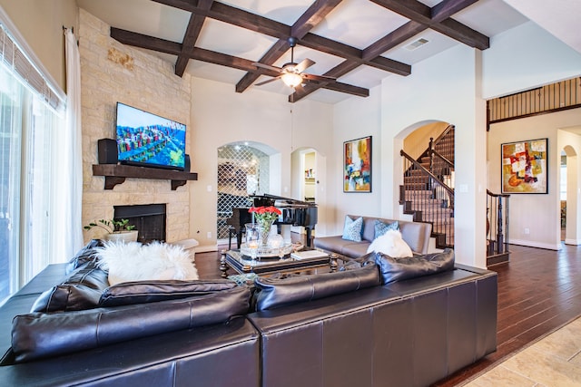 living area with visible vents, a fireplace, arched walkways, and coffered ceiling