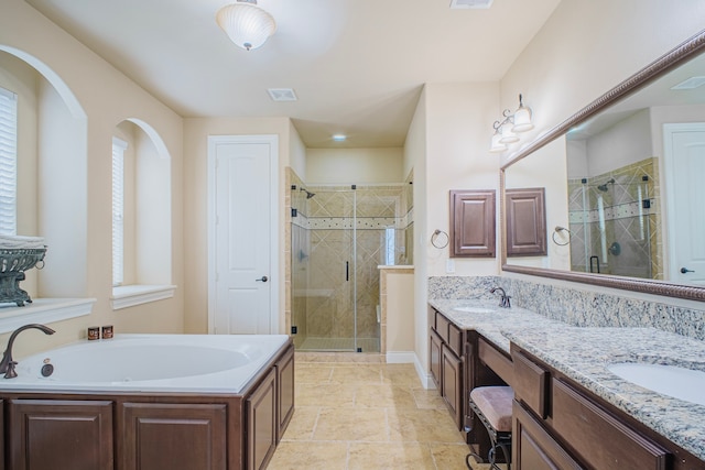 bathroom with a sink, double vanity, a shower stall, and visible vents