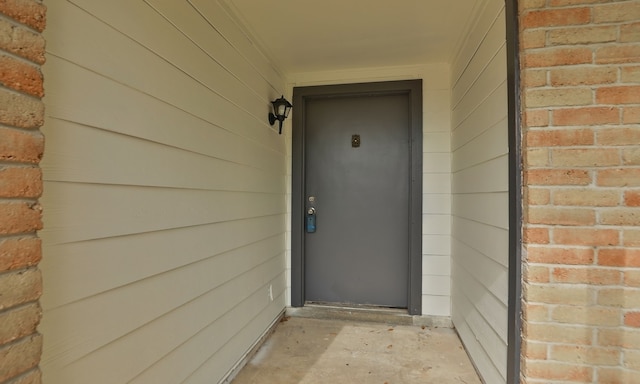 entrance to property featuring brick siding