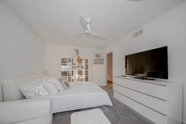 bedroom with a textured ceiling, carpet floors, visible vents, and a ceiling fan