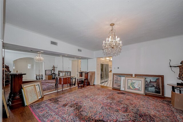 living area featuring an inviting chandelier, visible vents, and dark wood finished floors