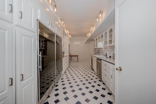 interior space featuring wine cooler, backsplash, vanity, and a notable chandelier