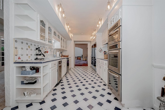 kitchen featuring glass insert cabinets, light floors, white cabinetry, open shelves, and a sink