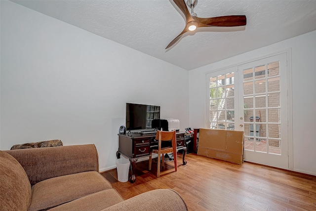 office space with a textured ceiling, ceiling fan, wood finished floors, baseboards, and french doors