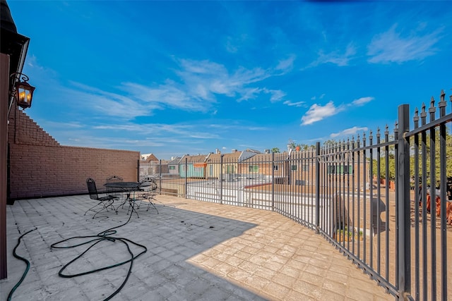 view of patio / terrace with fence and a residential view