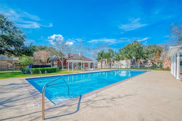 community pool with fence and a patio