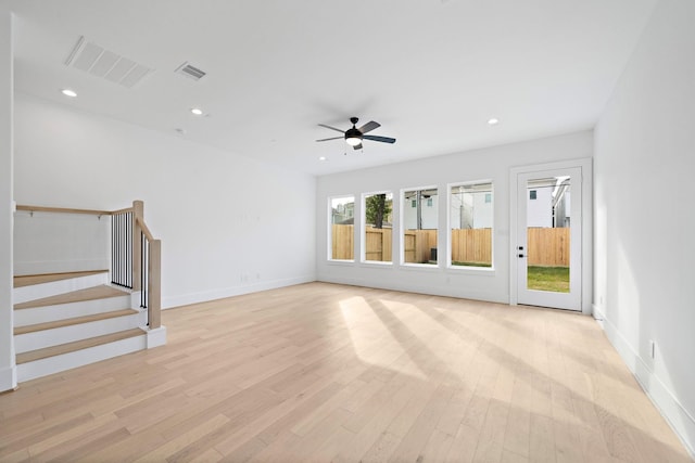 unfurnished living room with recessed lighting, visible vents, stairway, and light wood finished floors