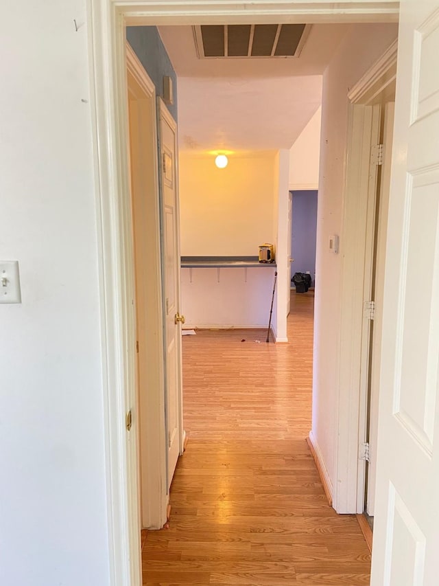 hallway featuring light wood-style floors and visible vents